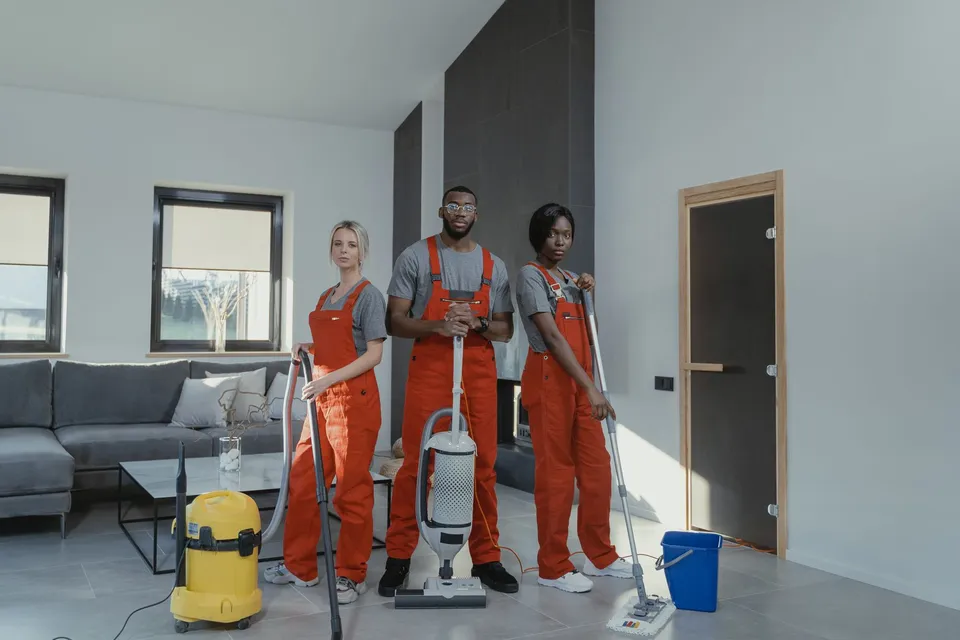 A professional cleaning team with equipment in a living room