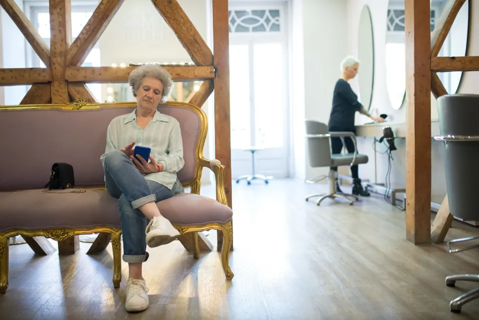 A customer waits on a couch in a bright hair salon